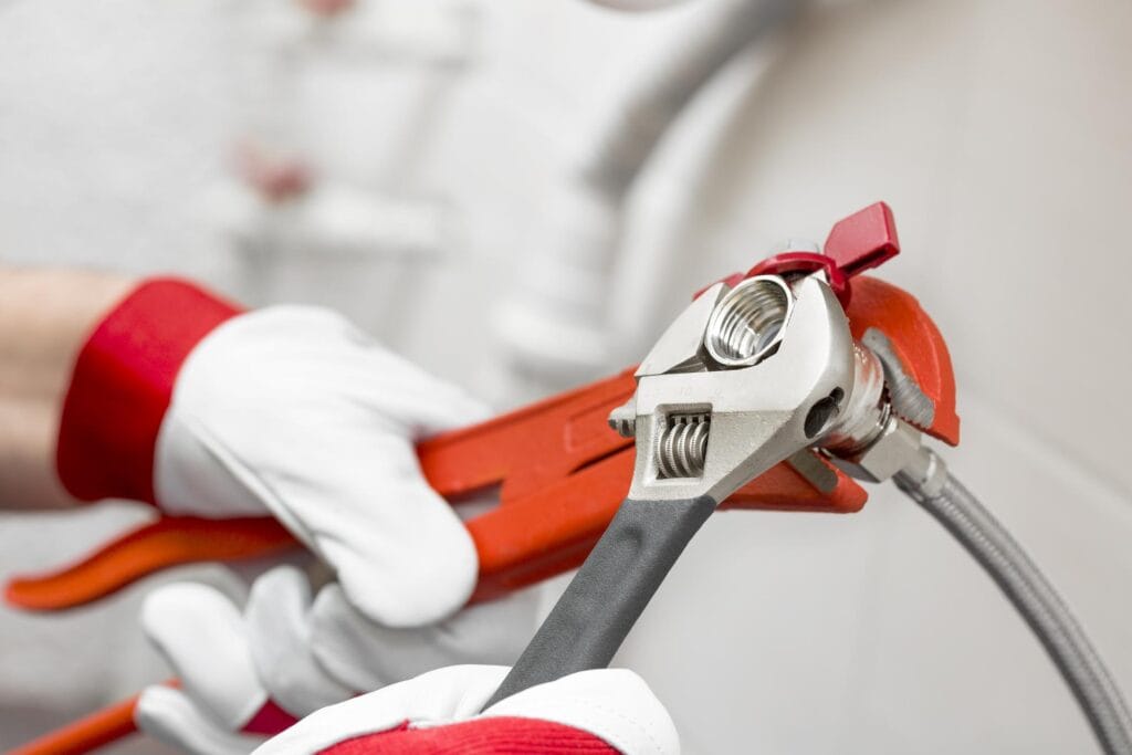 Plumber holding pipe wrenches for an emergency repair in Fort Walton Beach