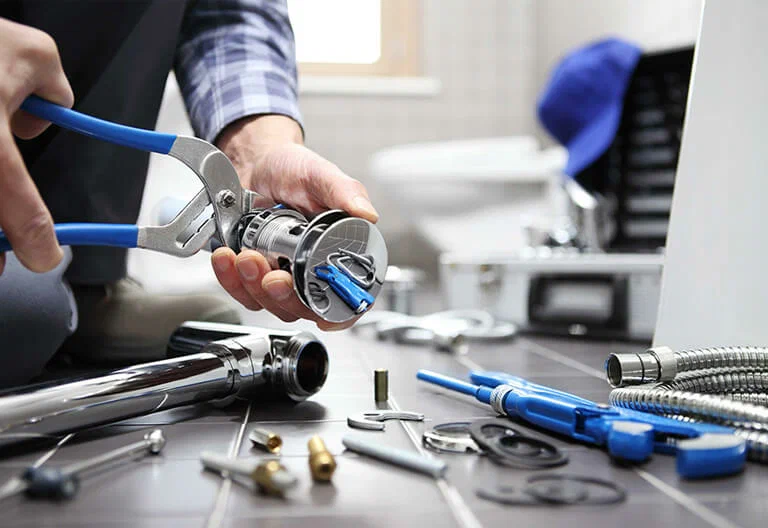 Technician repairing a plumbing fixture with professional tools in Fort Walton Beach