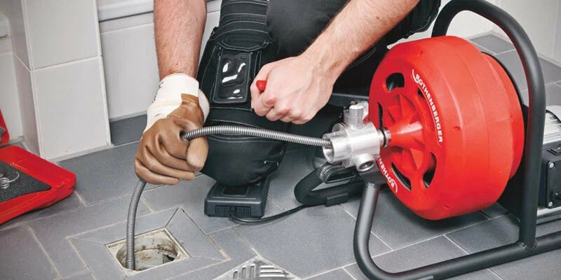 Plumber using a drain-cleaning machine in Fort Walton Beach