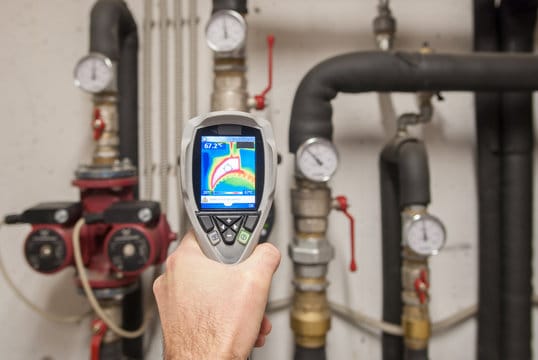 Plumber using a thermal imaging camera to inspect pipes in Fort Walton Beach