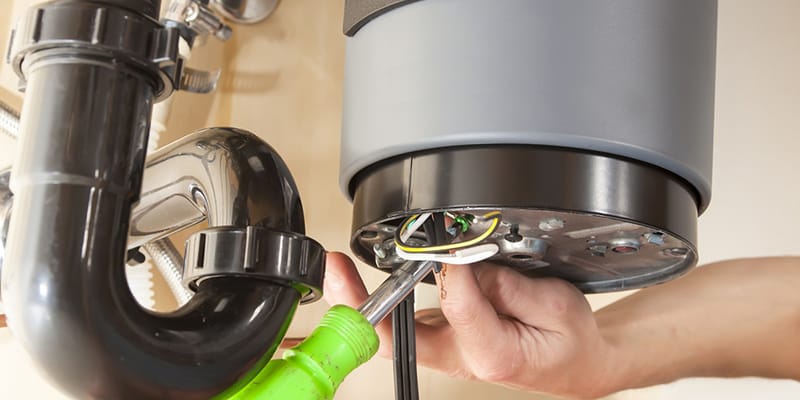 Technician repairing the heating element of a water heater in Fort Walton Beach
