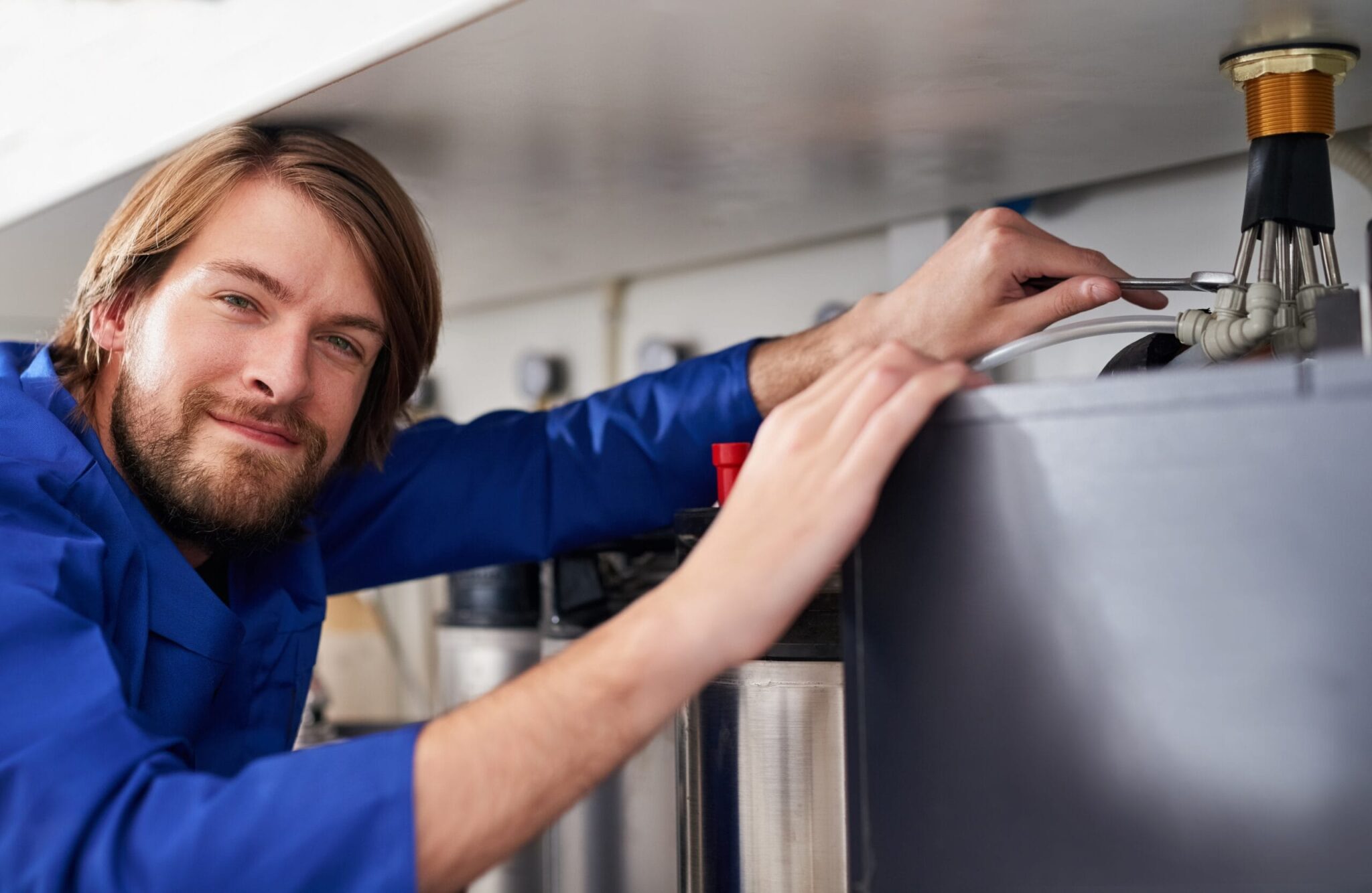 Technician servicing a residential water heater tank in Fort Walton Beach